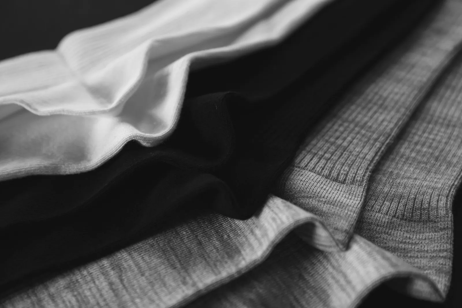 Close-up of folded ribbed knit socks in white, black and grey