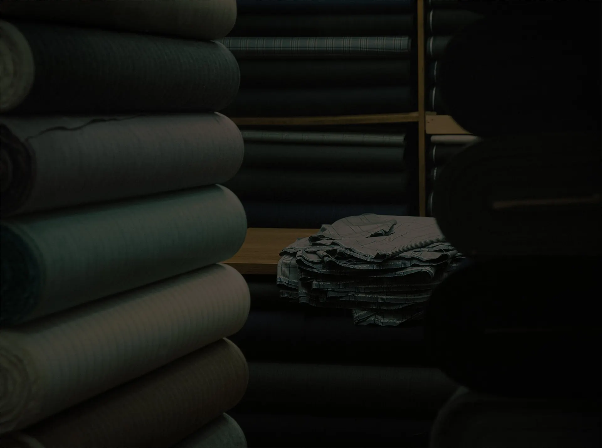 Rolls of suiting cloth stacked on shelves